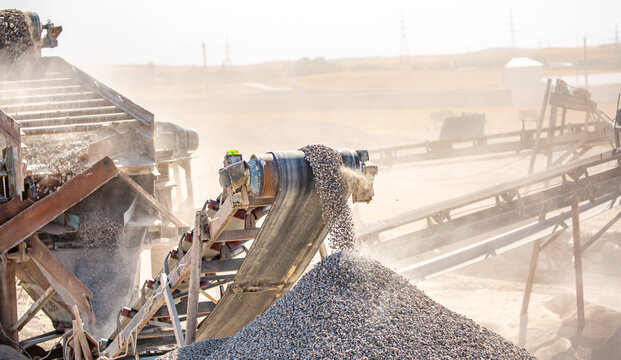 Vibrating screen stone crusher in operation. Crushing stones in a quarry for processing minerals, cement, limestone. Heavy and mobile equipment in a quarry for processing stone into building material.
