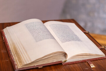 Obraz premium Open antique book on wooden table with soft focus