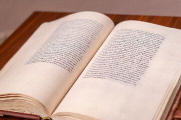Fototapeta premium Open antique book on wooden table with soft focus