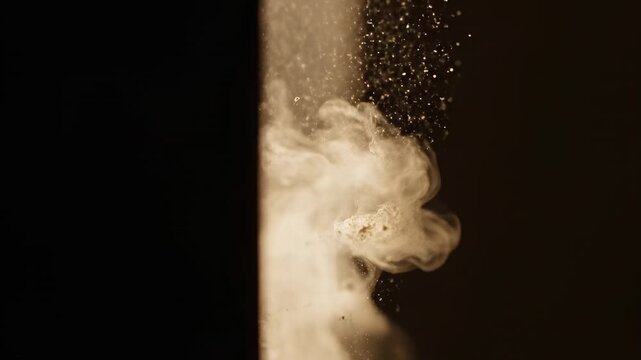 Accidental dust patterns in light beam. Dust motes float through a beam of light, creating fleeting shapes that appear and vanish by chance.