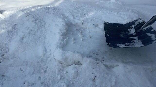 Person using equipment to remove packed snow from curbside area cautiously