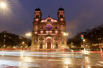 The facade of the Saint-Francois Xavier baroque church during the rainy night . Paris, France
