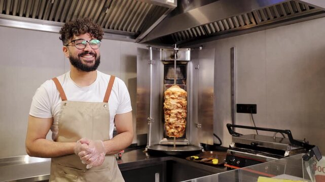 Restaurant employee holding and giving to the client a delicious doner kebab sandwich and a bottle of ayran drink, ready for customer service