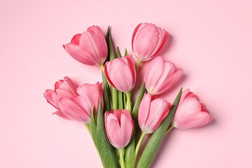 Obraz premium Bouquet of tulips on pink background, top view