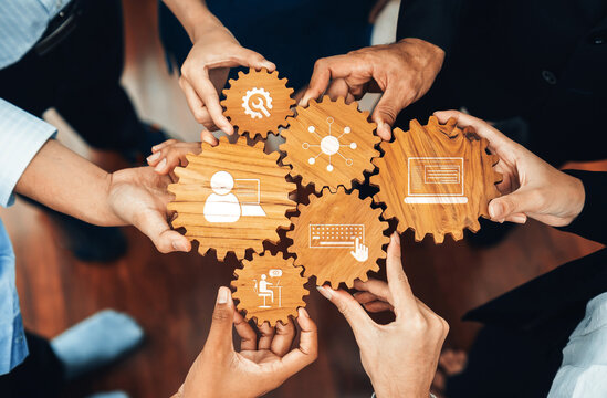 A dynamic scene showcasing hands working together around wooden gears, representing teamwork, technology, and innovation in a collaborative business setting. Amity