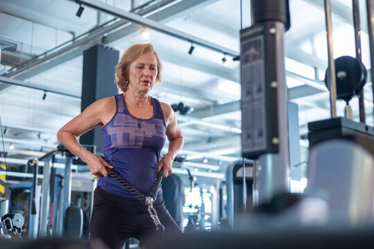 Senior woman doing cable rope exercise in gym, strength training and muscle building for elderly women over 60. strength training helps elderly women prevent sarcopenia, osteoporosis and age-related 