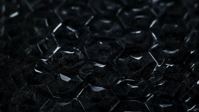 Black plastic bubble wrap texture closeup.