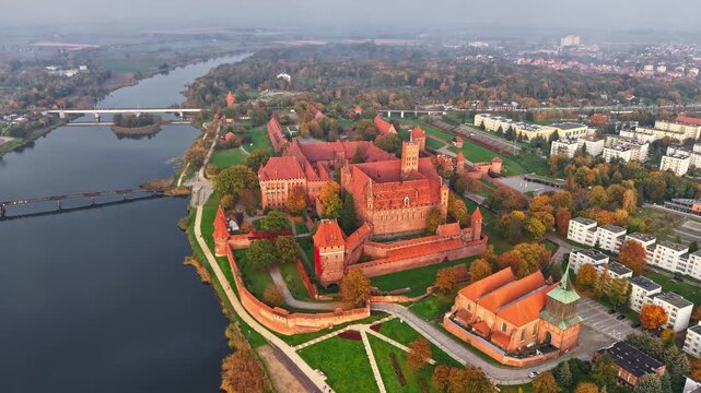 Malbork Castle aerial drone time lapse over medieval brick fortress and river landscape in autumn mist