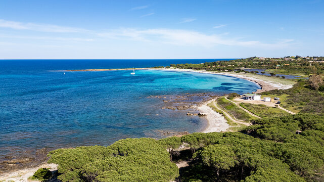 Aerial view of Porto Ainu beach with pine forest and crystal clear waters, Budoni, Sardinia.