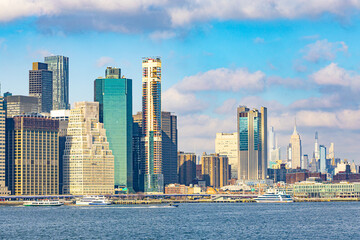 Obraz premium Panoramic view of the Lower Manhattan skyline in New York City with modern skyscrapers over the East River during a bright sunny day