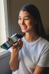 young Asian using artificial intelligence software by talking to her smartphone
