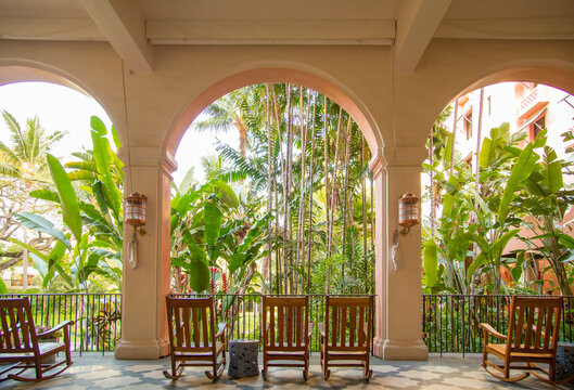 USA, Hawaii, Honolulu, Waikiki.  Rattan chairs looking out at tropical courtyard in luxury hotel.