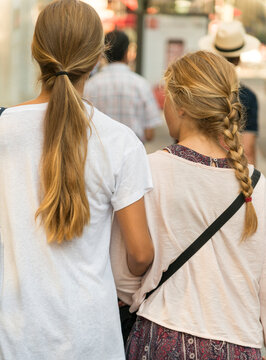 France, Paris.  Two young girls with blond hair.  One with pony tail, the other with braided hair.