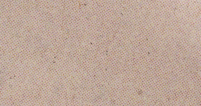 Stop-motion video of light handmade paper with tiny pink and yellow dot pattern and subtle fibers. Soft abstract backdrop for craft, stationery, packaging, and retro design.