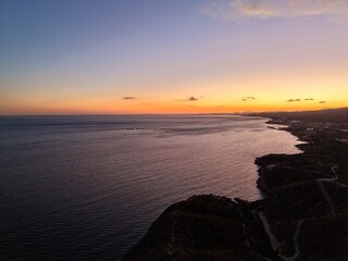 vivid coastal sunset, striking silhouette against colorful sky enhances visual storytelling potential © Nataliia