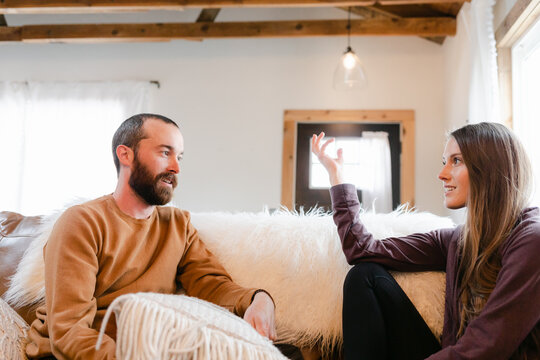 A Couple Sitting and Talking Together on a Couch
