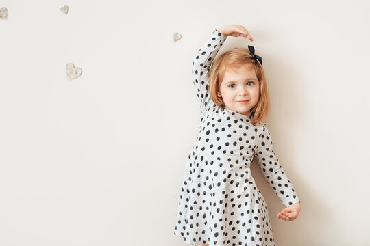 Cute little girl posing at a wall.