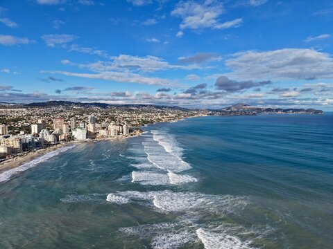Intense coastal storm with urban backdrop, Majestic shoreline battle between waves and city skyline