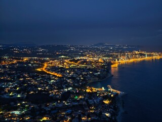 Obraz premium Night view shows coast. Nighttime aerial shot highlights brightly lit seaside settlements along roads
