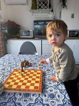 Toddler Playing Chess at Home

