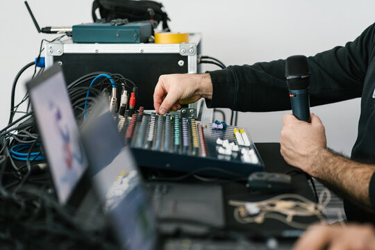 Crop man speaking into microphone, sound technician.