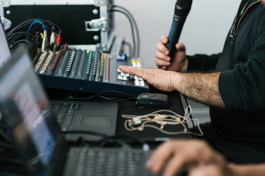 Unrecognizable man with microphone working on control