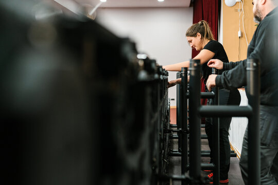 Female technician fixing LED display in auditorium