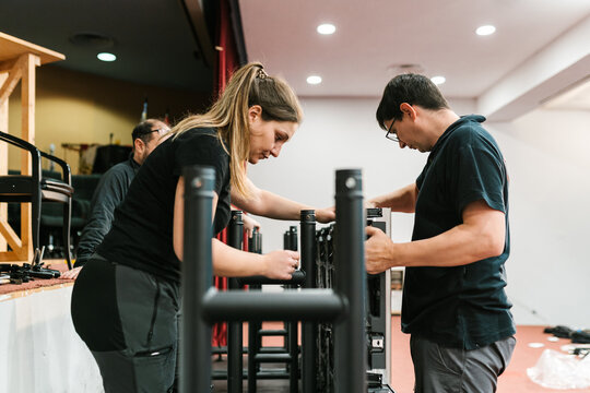 Concentrated technicians fixing LED displays in auditorium