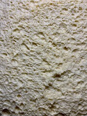 Obraz premium Close-up macro of fresh yeast dough with visible air bubbles and porous texture. Natural beige dough surface during fermentation. Abstract food background with organic pattern, baking process detail.