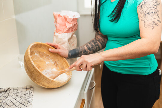 Tattooed woman mixing flour