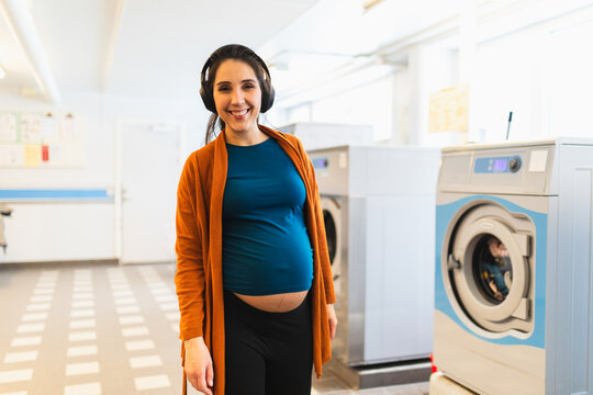 Young pregnant woman doing laundry