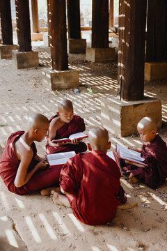 Young Monks studying scriptures under wooden pillars