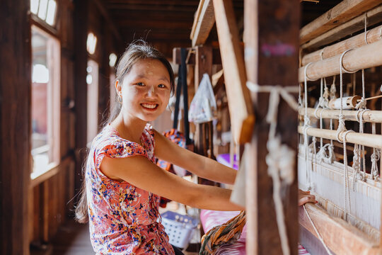 Smiling Weaver at a Wooden Loom