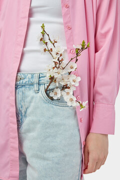 Waist of woman dressed in buttoned denim pants with apricot stick