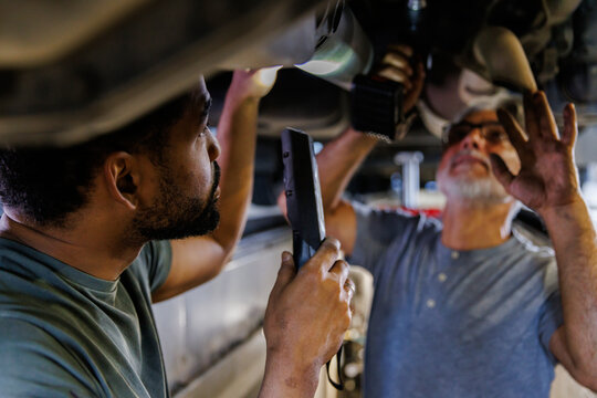 Mechanic repairing motor vehicle at garage