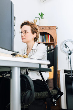 Woman in electric wheelchair working from home on her computer