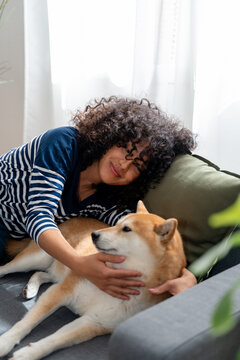Woman cuddling with her shiba inu dog