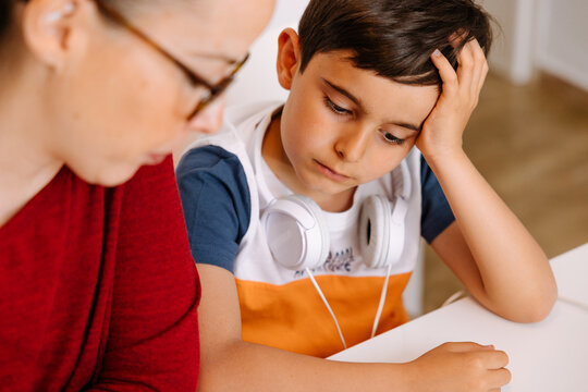Mother helping her frustrated young son with homework