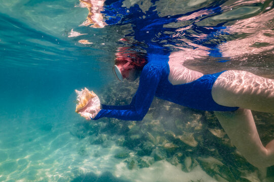 Woman Snorkeling with Conch Shell Anegada BVI on Caribbean Vacation