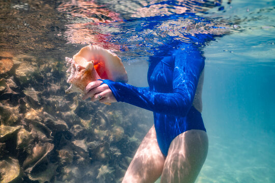Woman Holding Large Conch Shell Anegada BVI on Caribbean Vacation