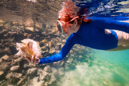 Caribbean Vacation Woman Snokeling with Conch Shell