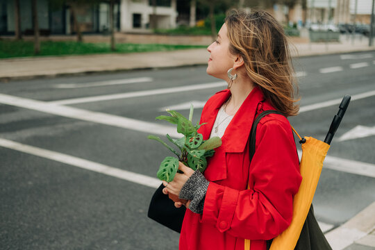 Woman with a plant crossing the road
