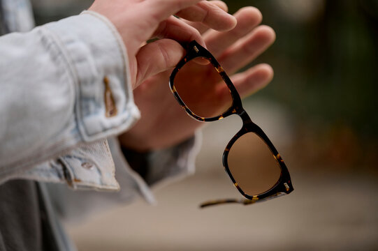Male hands holding glasses outdoors