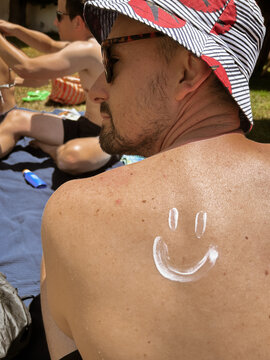 UGC sunscreen smiley on man back 