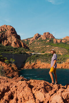 Man exploring rocky coast of French Riviera in summer 