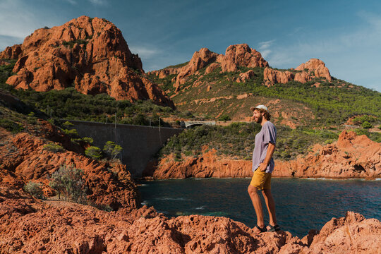 Man exploring rocky coast of French Riviera in summer 