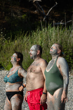 Friends of generation x enjoying natural cosmetic clay on the seacoast