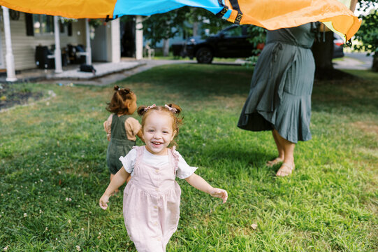 playful happy lgbtq family with mothers and toddler daughters