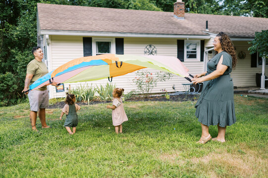 playful happy lgbtq family with mothers and toddler daughters