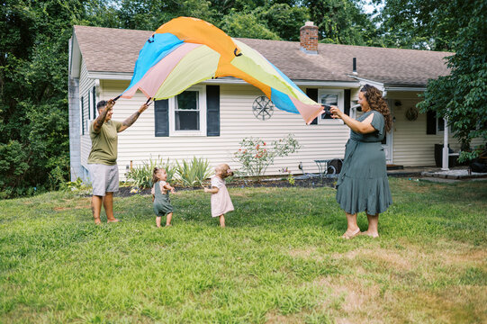playful happy lgbtq family with mothers and toddler daughters